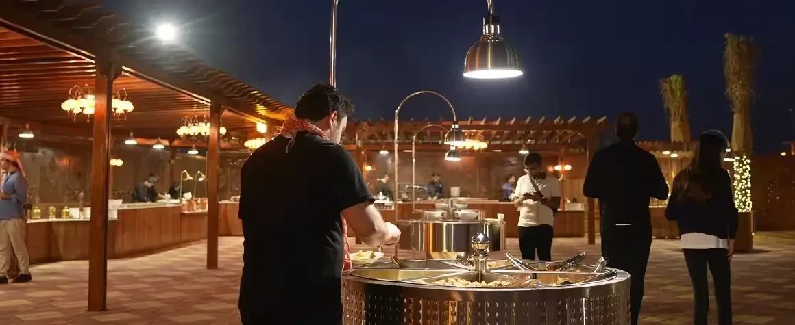 Guests enjoying BBQ dinner under the stars on evening desert safari