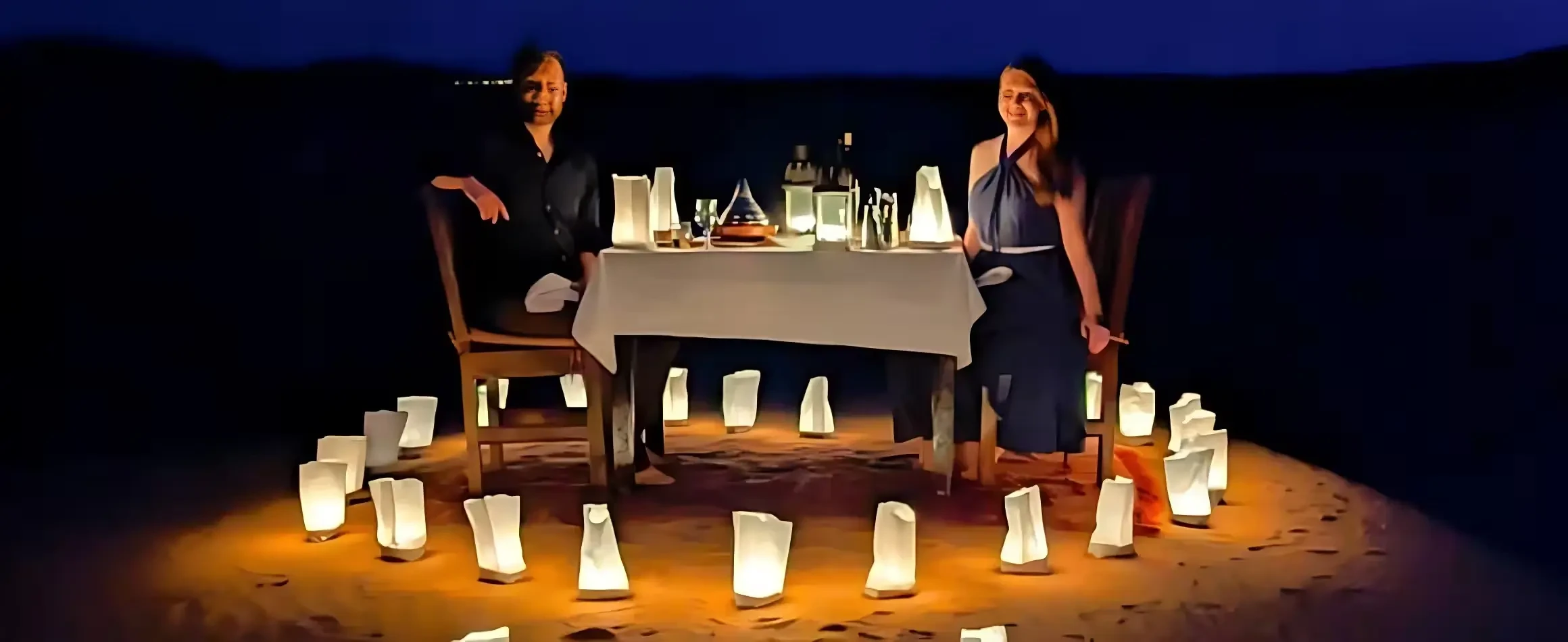 Couple enjoying romantic desert safari night with warm lighting ambiance