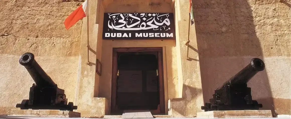 Historic entrance of Dubai Museum with two cannons at the gate