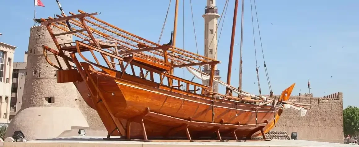 Traditional wooden dhow boat displayed on the floor during city tour
