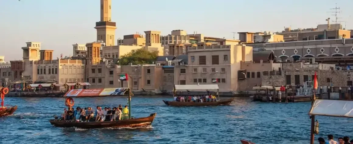 Scenic water view with boats and tourists enjoying a ride in Dubai