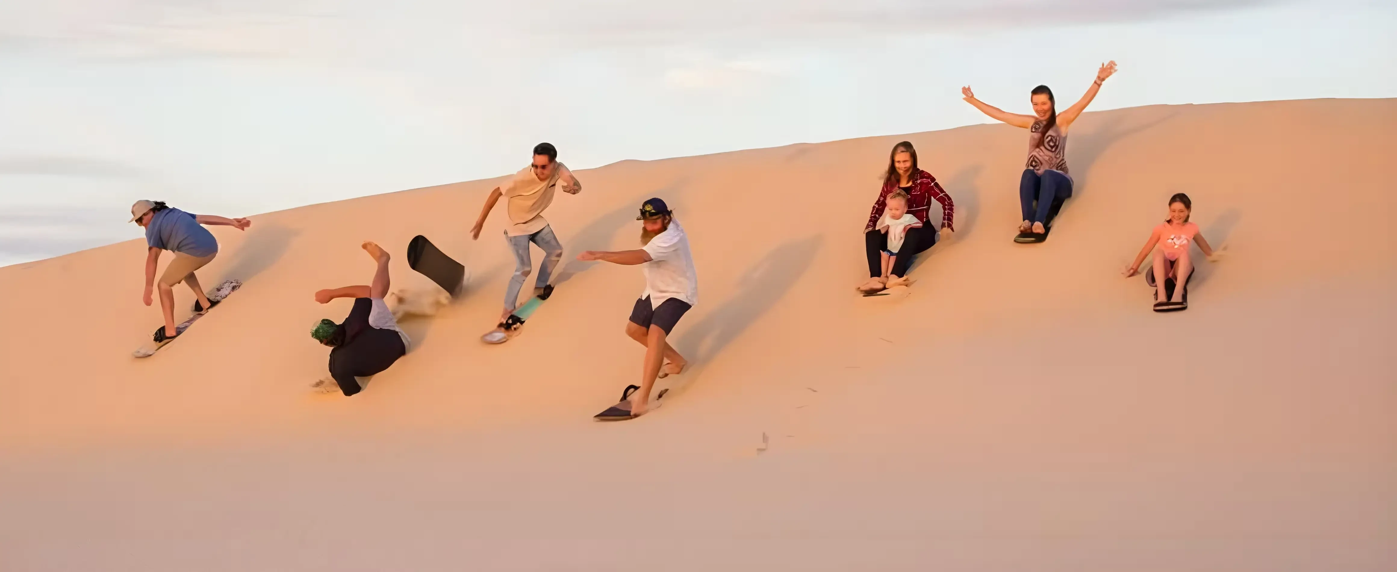 Group performing sand drift without vehicles during thrilling desert safari