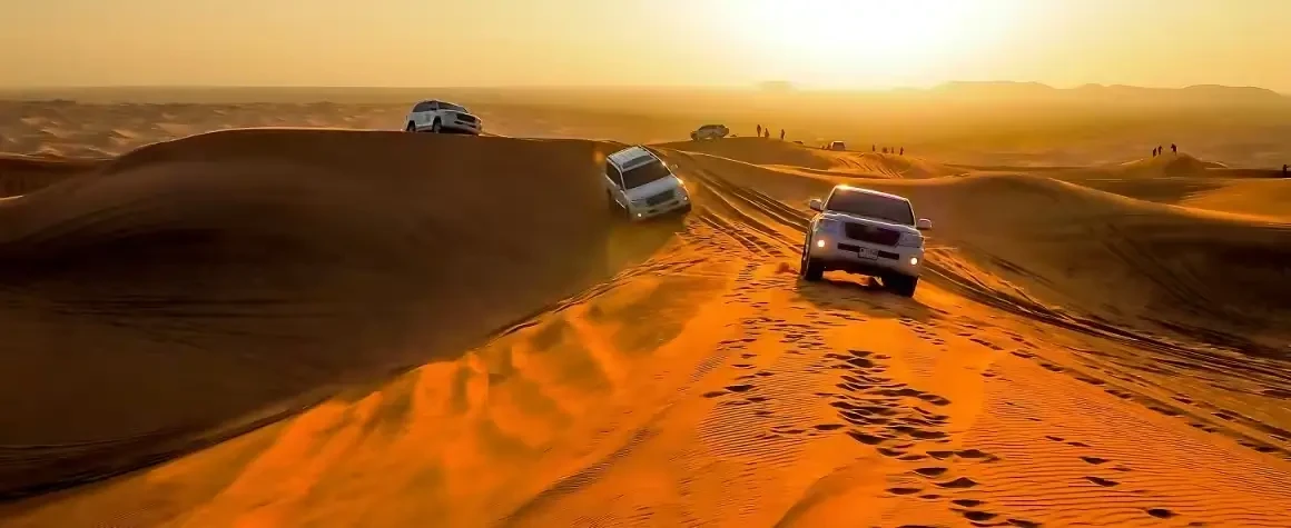 4x4 cars drifting across desert dunes during evening desert safari Dubai