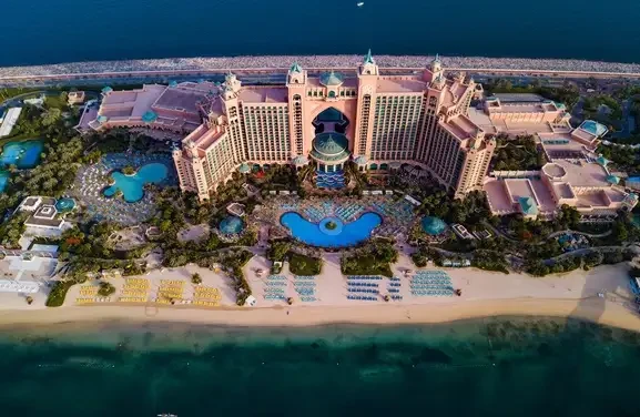 A large beachfront hotel, Atlantis the Palm, Dubai, showcasing its iconic architecture against the ocean backdrop.