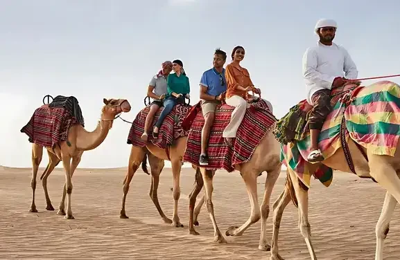 A majestic white mosque is located next to a serene canal, showcasing its architectural beauty.