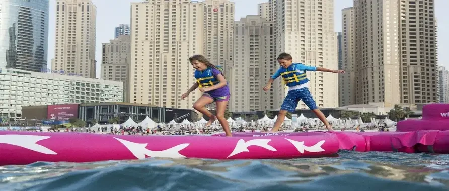 Two children play on a pink inflatable raft in the water during a game in Dubai, Saudi Arabia.