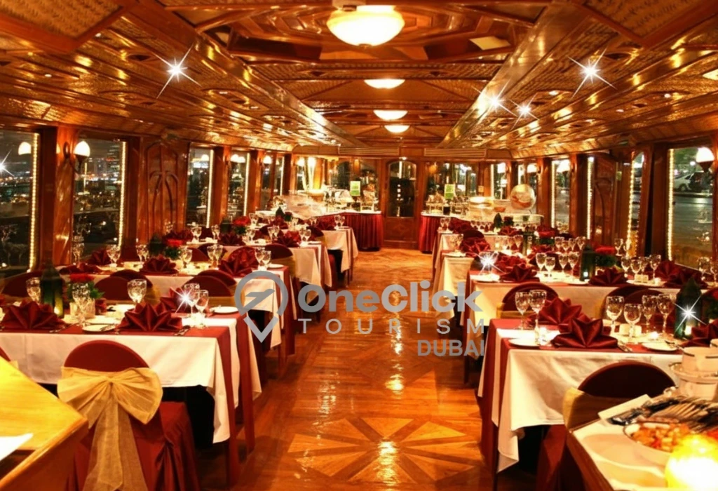 The elegant indoor dining area of a Dubai Marina dhow cruise featuring red table linens and warm traditional decor.