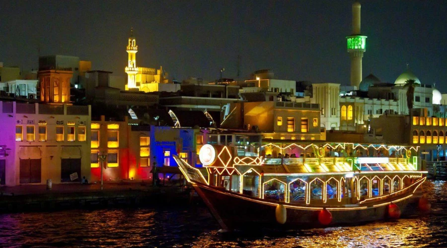 Traditional dhow cruise sailing along Dubai Creek at night