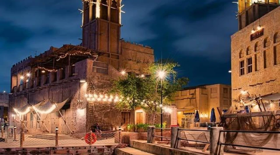 Historic Dubai Creek waterfront with traditional architecture at night