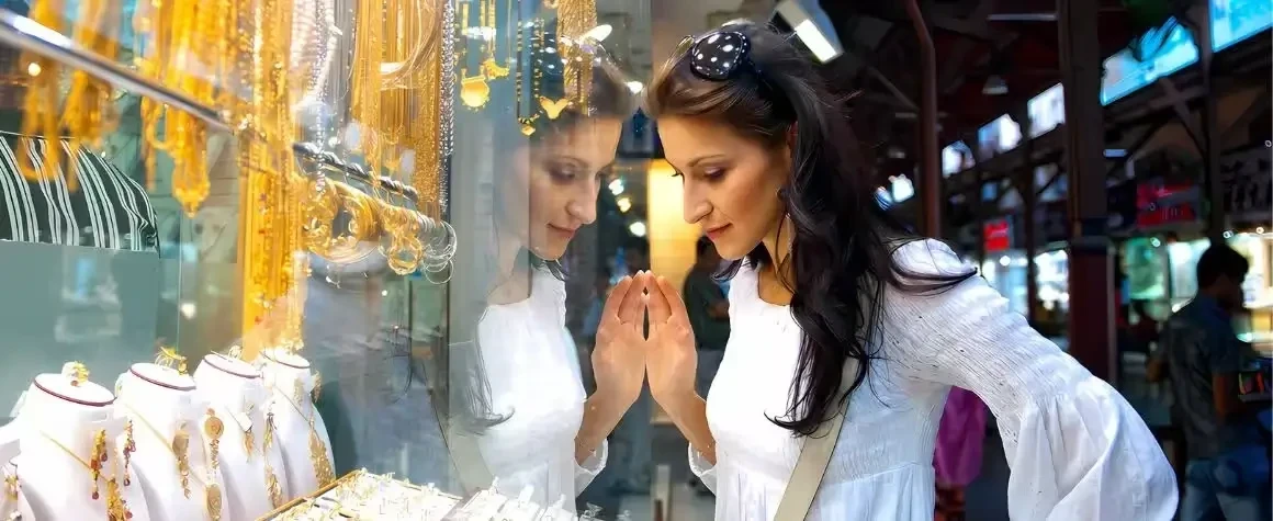 Girl browsing jewelry at traditional souk during Dubai city tour