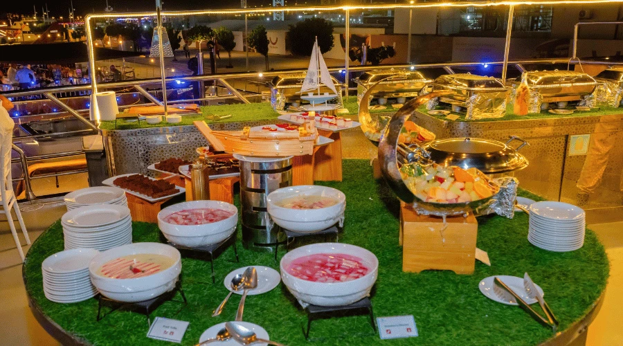 Five-star international buffet dinner spread with desserts and hot dishes served aboard a Dubai Marina dhow cruise.