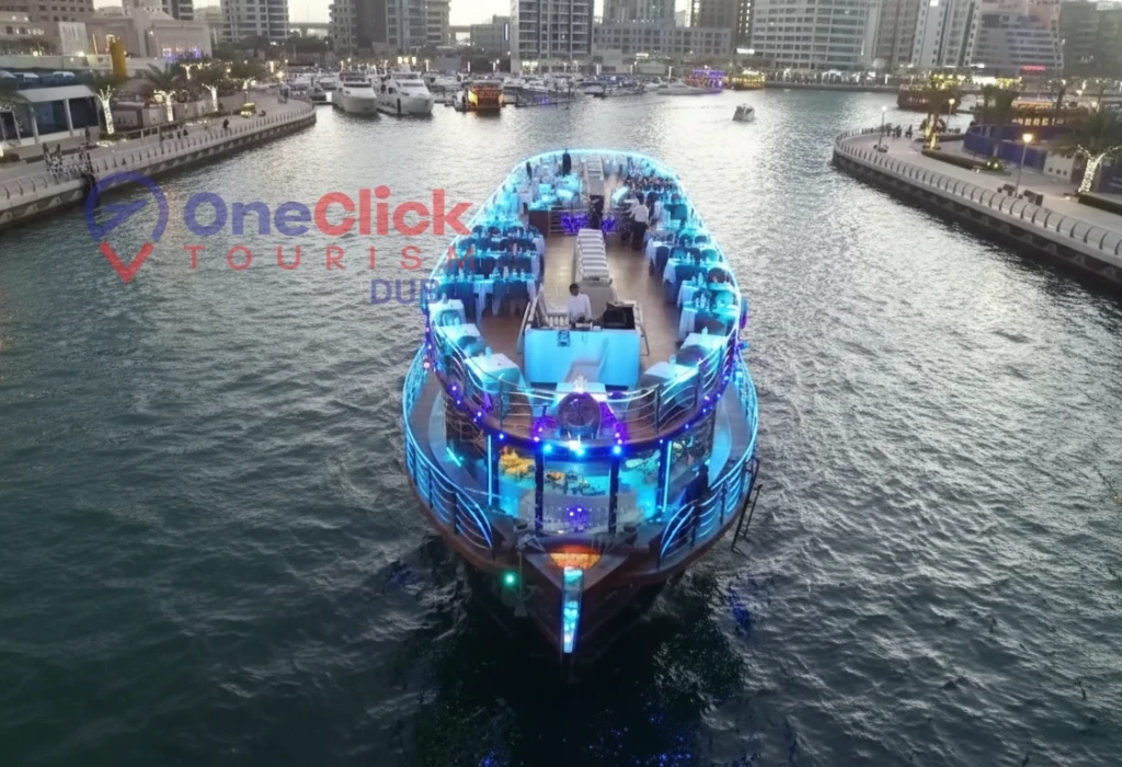 Overhead view of a luxury dinner cruise boat with vibrant blue neon lighting on the Dubai Marina canal.