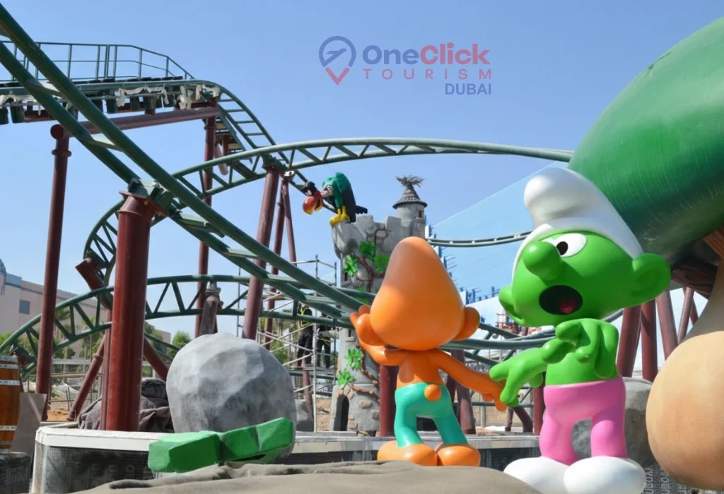 Green and orange Smurf character figures standing near the Smurfs Village Express roller coaster at Motiongate Dubai.