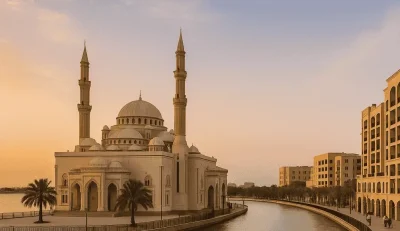 In Dubai, a grand white mosque is located next to a serene canal, highlighting the city's blend of culture and nature.