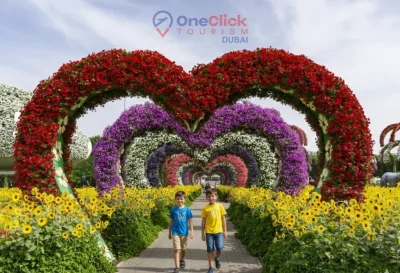 Two young boys walking through the multicolored heart-shaped flower archway in Dubai.