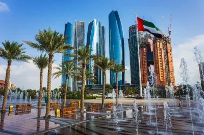 The UAE flag waves proudly in front of a fountain in Abu Dhabi, showcasing national pride and beauty.