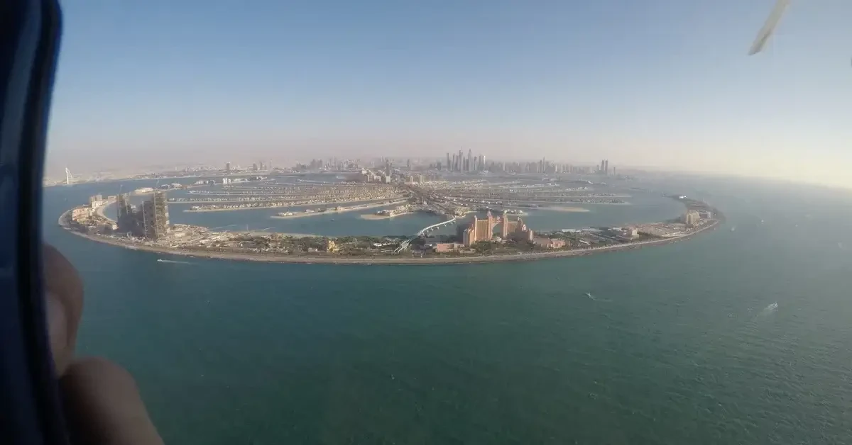 A traveler photographing the cityscape of Dubai from a helicopter, enjoying a panoramic view.
