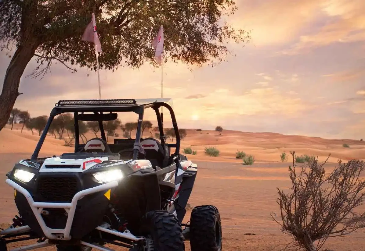 A UTV stands still in the desert at sunset, highlighting the perfect setting for an exhilarating buggy ride.